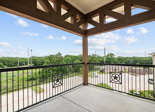 the view from the balcony of a condo with a view of the yard and trees