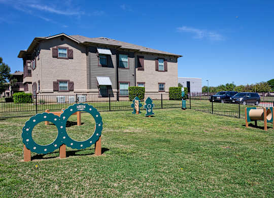 A green sign with two circles on it is in front of a building.