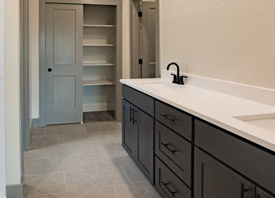 A bathroom with a sink, mirror, and a cabinet.