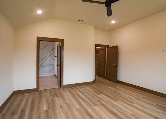 A room with a wooden floor and a ceiling fan.