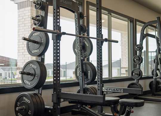 A black weight bench with a barbell on it.
