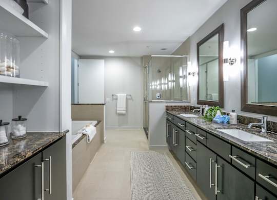 A bathroom with a sink, mirror, and a towel hanging on the wall.