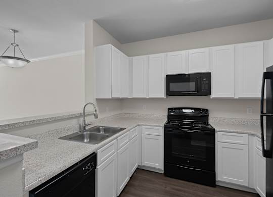 a kitchen with white cabinets and black appliances