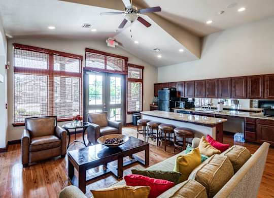 a large living room with a kitchen and a ceiling fan