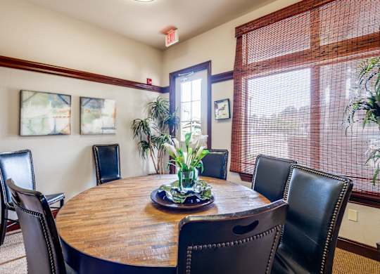 a dining room with a wooden table and leather chairs