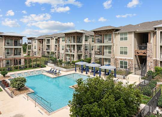 a swimming pool with an apartment building in the background