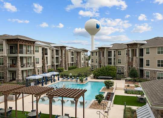an aerial view of an apartment complex with a pool and water tower