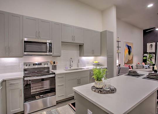 A modern kitchen with a stainless steel refrigerator and oven.