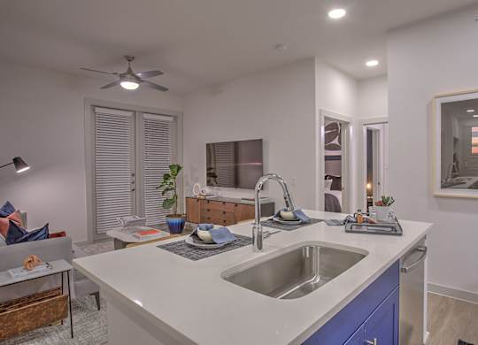 A modern kitchen with a white countertop and blue cabinets.