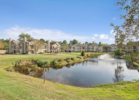 A pond in front of a row of houses.