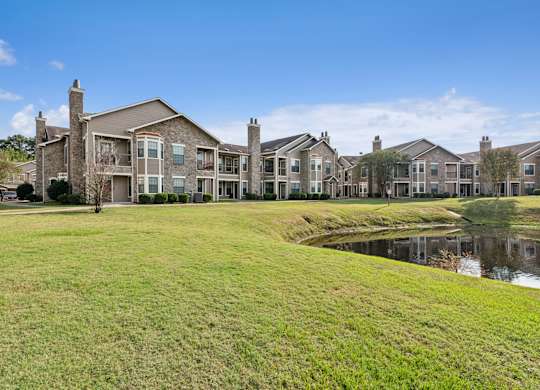 A row of houses with a pond in front.