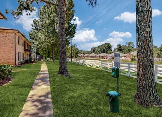 a sidewalk in front of a white fence and a fire hydrant