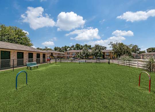 a playground in the backyard of a fenced in yard