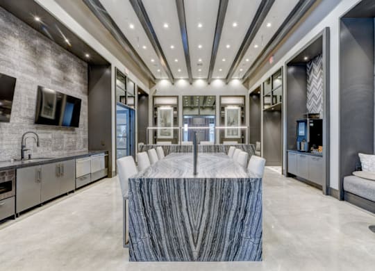 A modern kitchen with a marble table in the center.