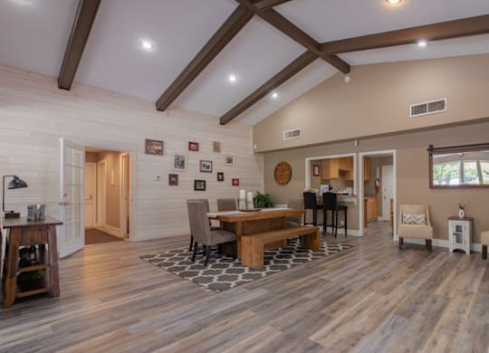 A spacious living room with a wooden floor and a high ceiling.