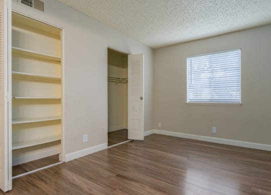 A room with a window and a door is empty and waiting to be furnished.