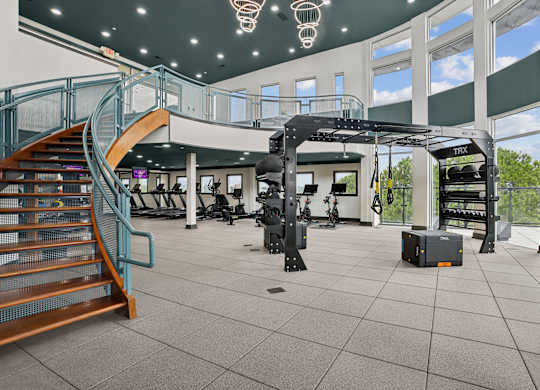 A gym with a staircase and exercise equipment.