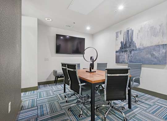 A conference room with a large painting on the wall and a television.