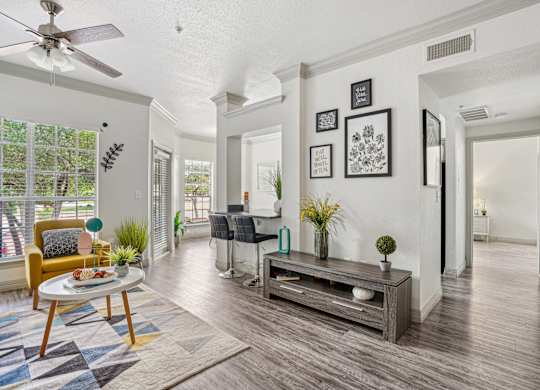 A living room with a yellow chair and a wooden coffee table.
