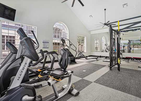 A gym with a variety of equipment including a stationary bike and a pull up bar.
