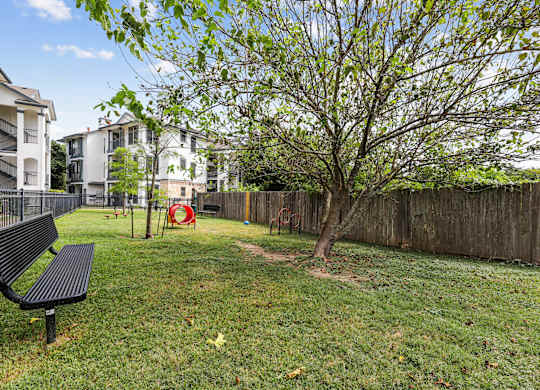 A black bench sits in a grassy yard.