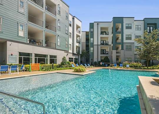 A swimming pool in front of apartment buildings.