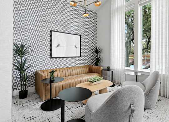 A living room with a brown sofa, a black table, and a white wallpaper.