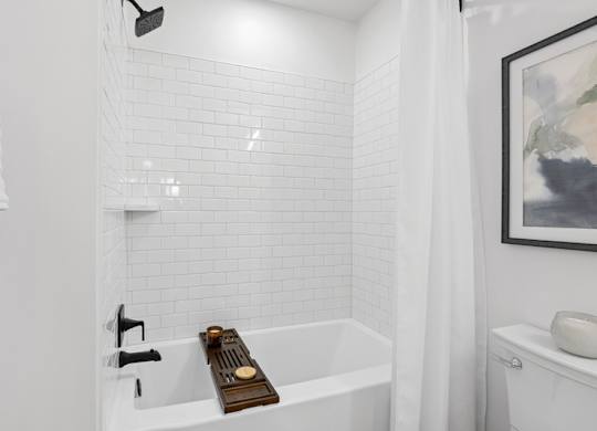 A white bathroom with a white tub and a white towel.