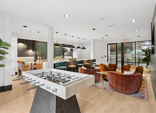 A foosball table is in the middle of a room with a couch and chairs.