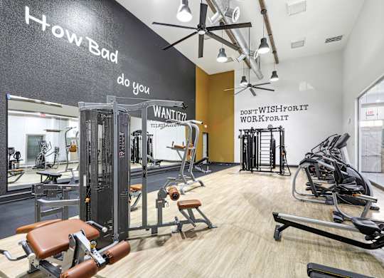A gym with a variety of equipment including treadmills, weights, and exercise machines.