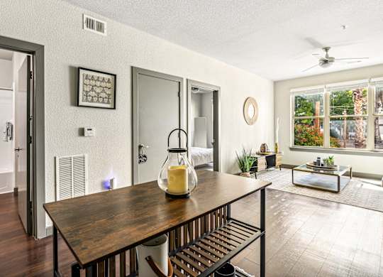 the dining room and living room of a house with a table and a large window