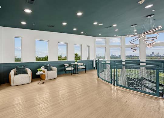 A room with a long table and chairs with a view of the city.