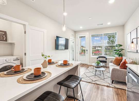 A modern kitchen with a dining area and a view of the backyard.