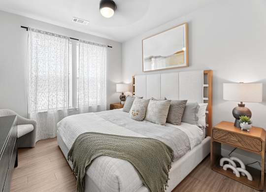 A bedroom with a large bed and a wooden nightstand.