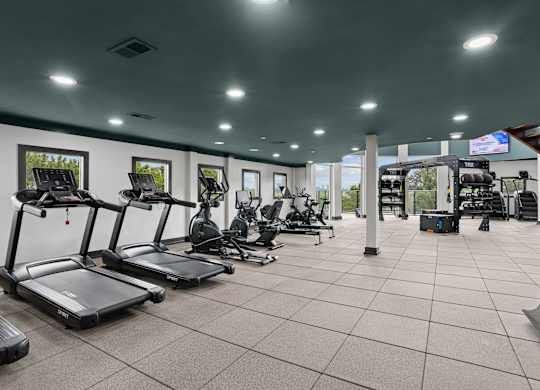 A gym with treadmills, exercise bikes, and other equipment.