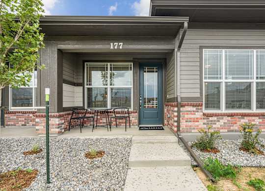 A house numbered 177 with a blue door and a small garden in front.