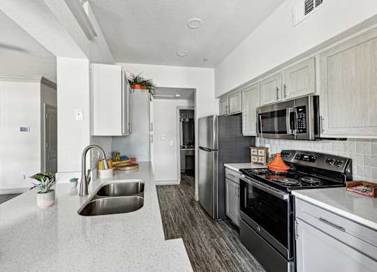 A kitchen with stainless steel appliances and white cabinets.