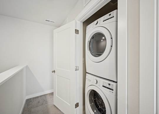 A white washing machine is in a cabinet in a room.
