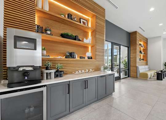 A modern kitchen with a wooden wall and grey cabinets.