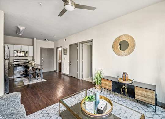 a living room with a table and a ceiling fan
