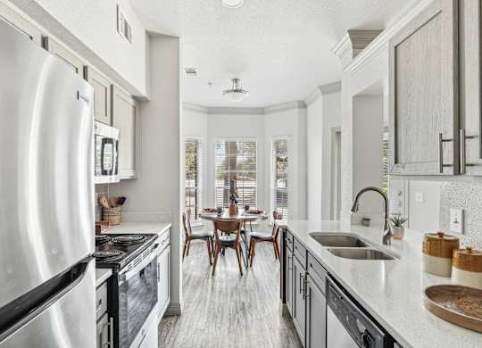 A modern kitchen with a large island and stainless steel appliances.