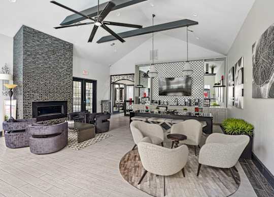 A modern living room with a stone fireplace and a large fan.