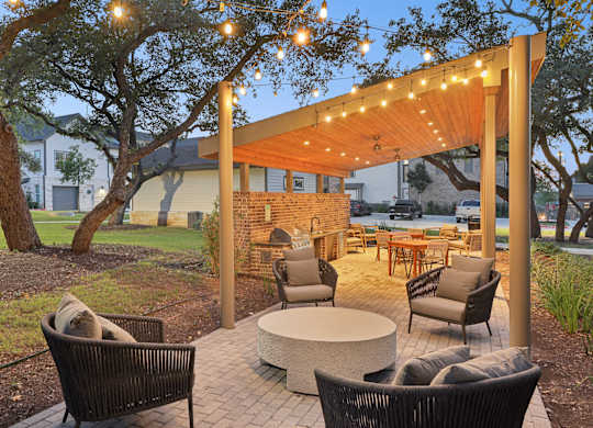 A patio with a table, chairs, and a fireplace.