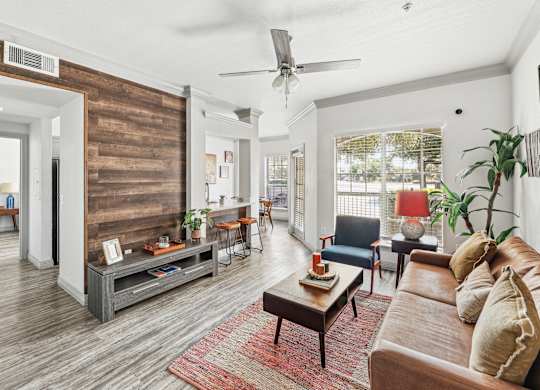 A living room with a wooden floor and a large window.