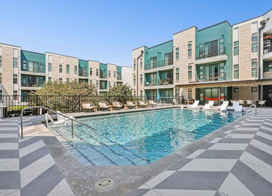 A swimming pool in front of a building with a black and white checkered floor.