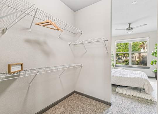 a bedroom with a white closet and a bed and a glass window