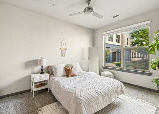 a bedroom with a bed and a large window