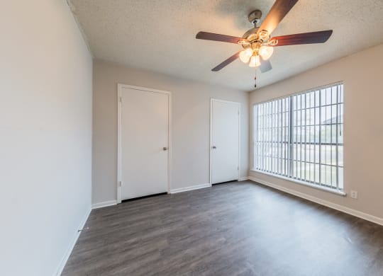 an empty living room with a ceiling fan