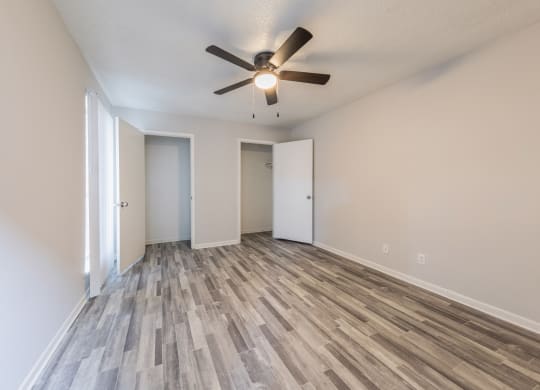 an empty living room with a ceiling fan