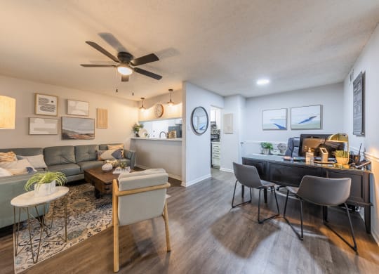 a living room and dining room with a ceiling fan and hardwood floors